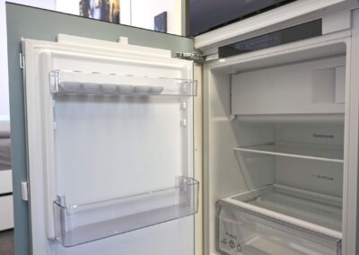 Geöffneter Kühlschrank mit leeren Regalen in moderner Küche