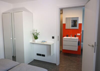 Modernes Schlafzimmer mit Badezimmer und schlichter Dekoration