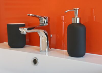 Moderne Badezimmerarmaturen auf orangem Hintergrund