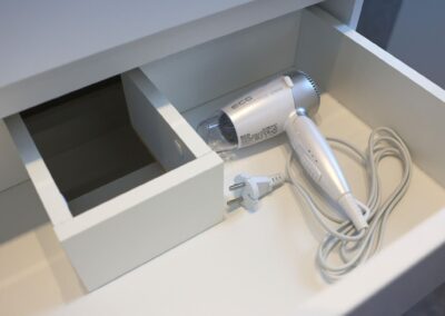 Haartrockner in einer weißen Schublade ordentlich verstaut