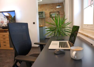 Laptop-Arbeitsplatz am Fenster mit warmem Abendlicht in der Ferienwohnung Petra Ilmenau – Workation im Thüringer Wald