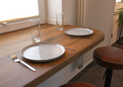 Stilvoll gedeckter Esstisch mit Holzstühlen und Geschirr in der Ferienwohnung Petra Ilmenau – gemütlich speisen im Thüringer Wald